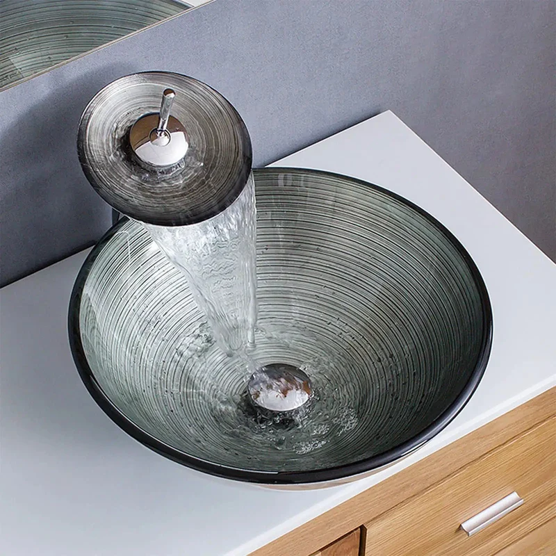 Slick Tempered Glass Vessel Sink With Fly Spiral Pattern And Waterfall Faucet Offers Round Shape Toughened Durability Scratch Proof Surface Easy Wiping Care And Includes Pop Up Drain For A Total Bathroom Glow Up